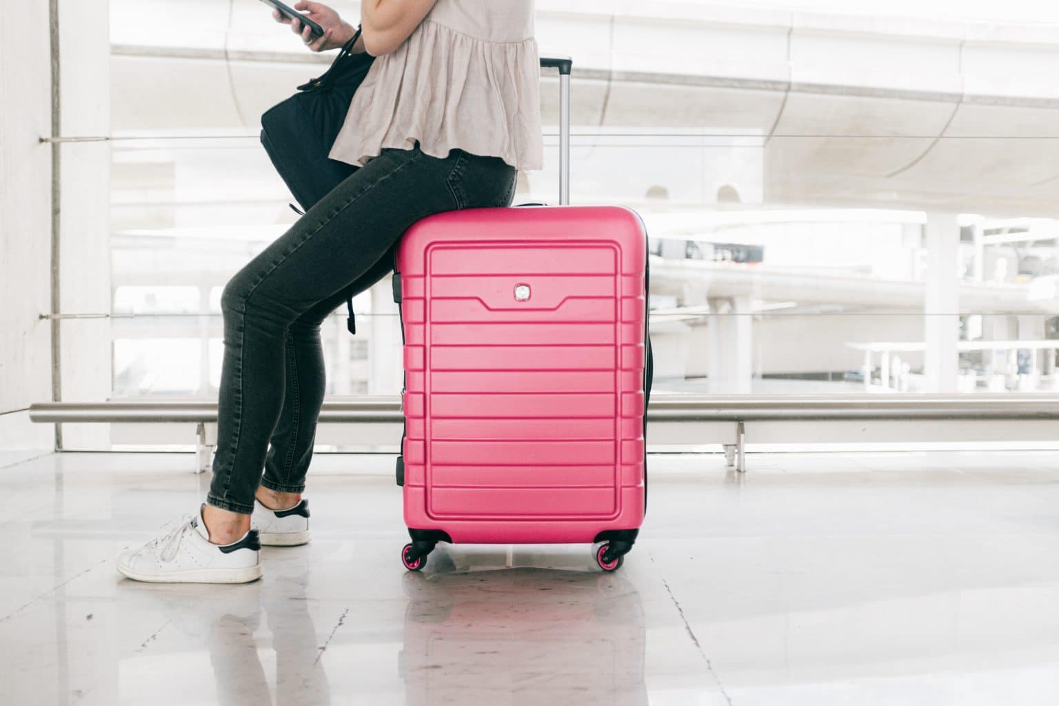 Woman with luggage waiting in an airport.