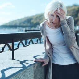 Older woman having a dizzy spell while out for a walk.