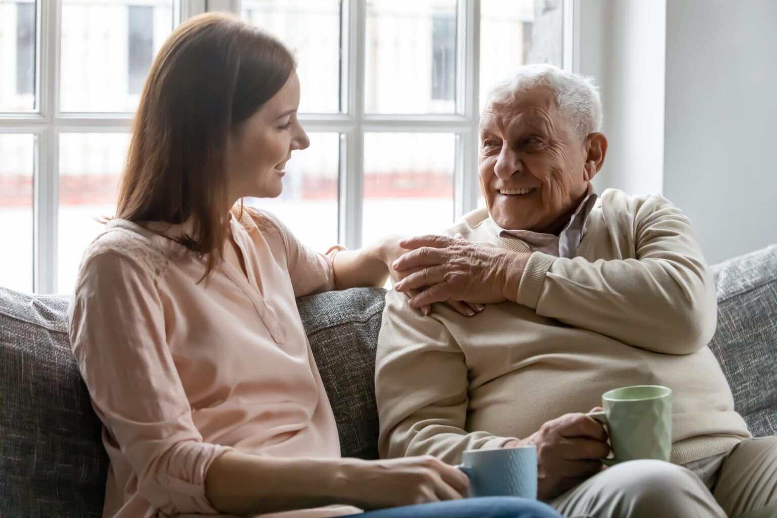 Smiling adult daughter talking with her older father.