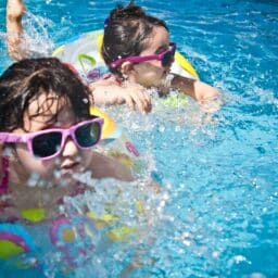 Two young girls swimming in a pool.