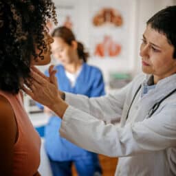 ENT doctor examining a female patient in a medical office.