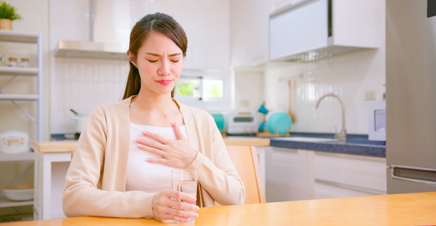 Young woman experiencing acid reflux.