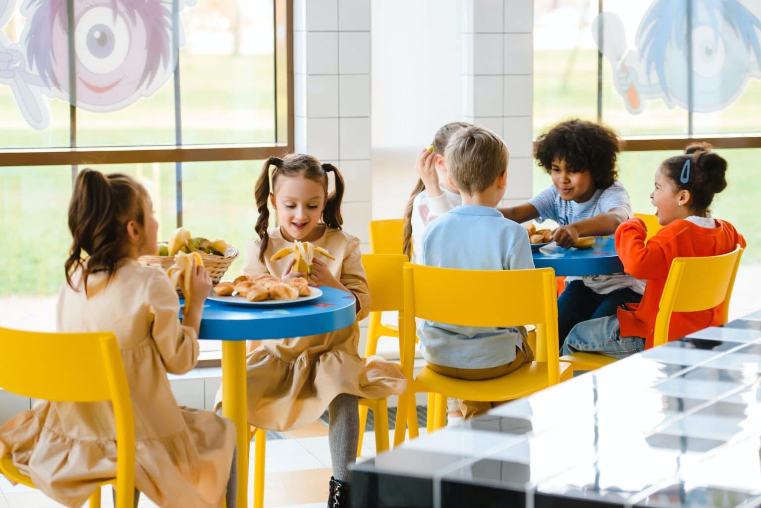 Group of young children eating lunch at school.