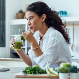 Woman drinking a green juice for her heart health
