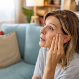 Woman with tinnitus holds ear