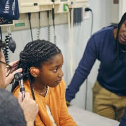 Young girl gets ear examined by doctor