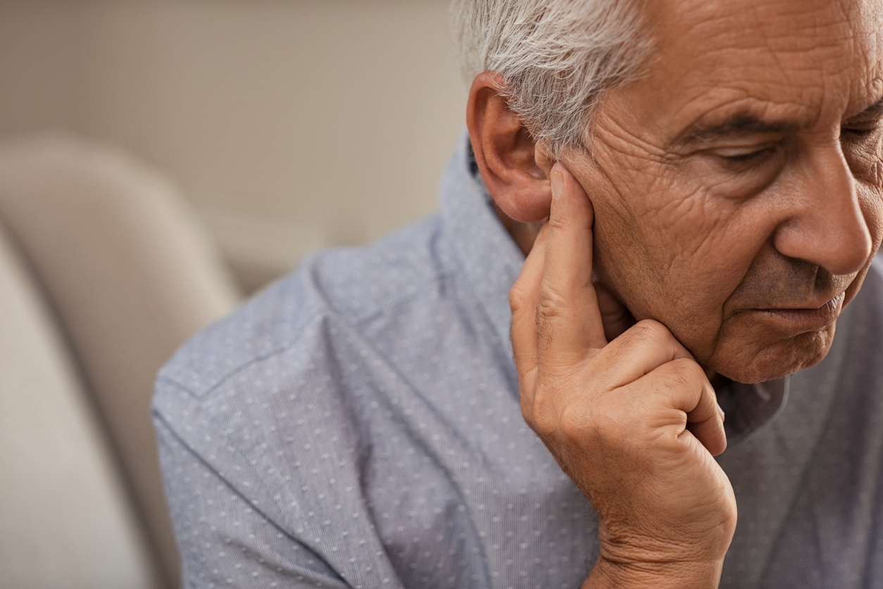 Man holds ear for hearing loss