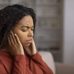 Stressed woman holding her ears